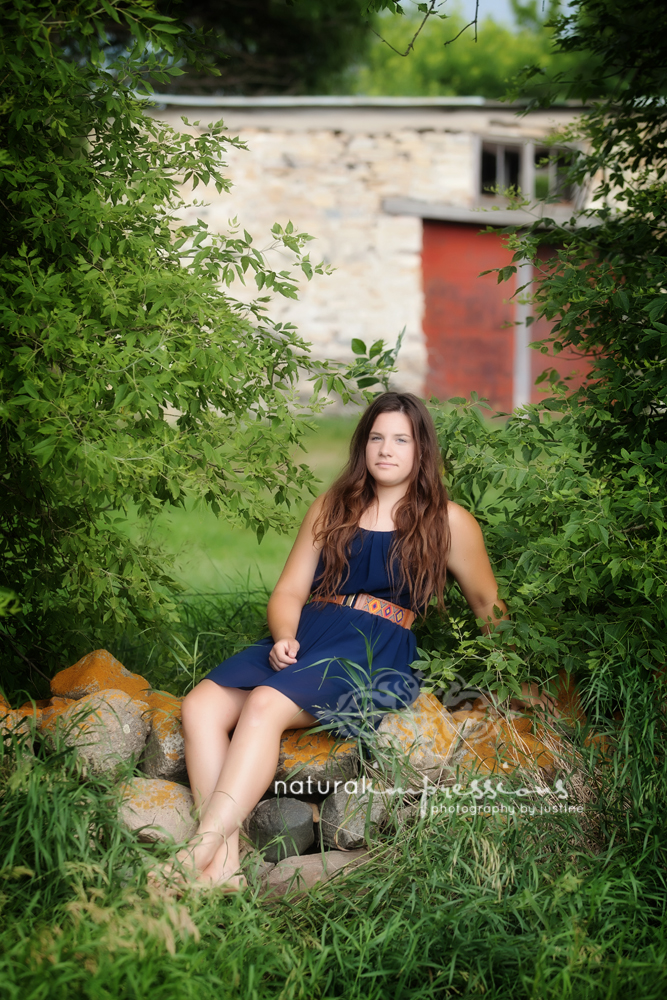 Senior girl posing by historic barn