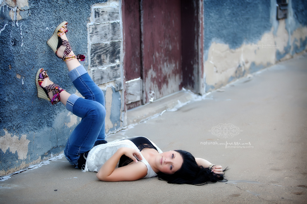 senior girl with feet on alley wall