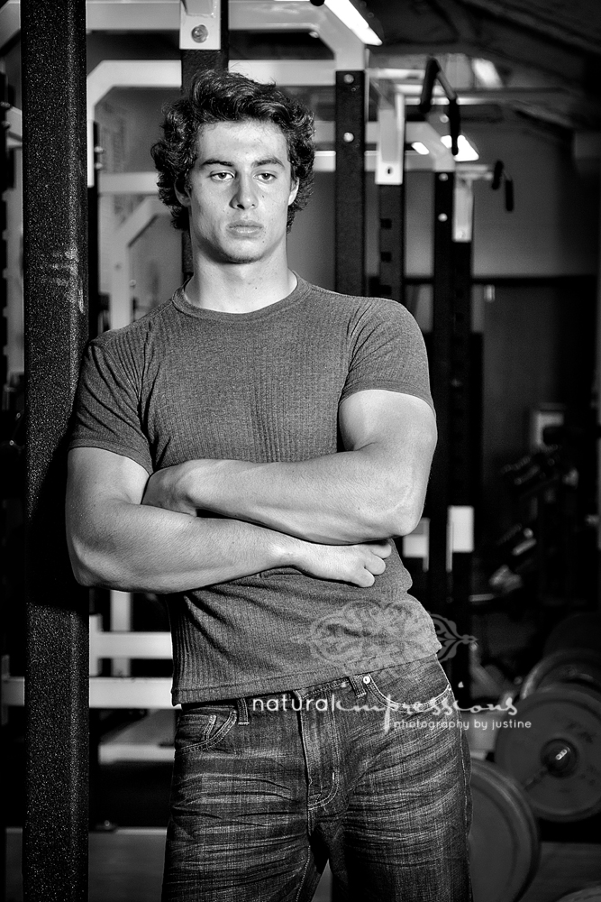 senior boy poses in weight room