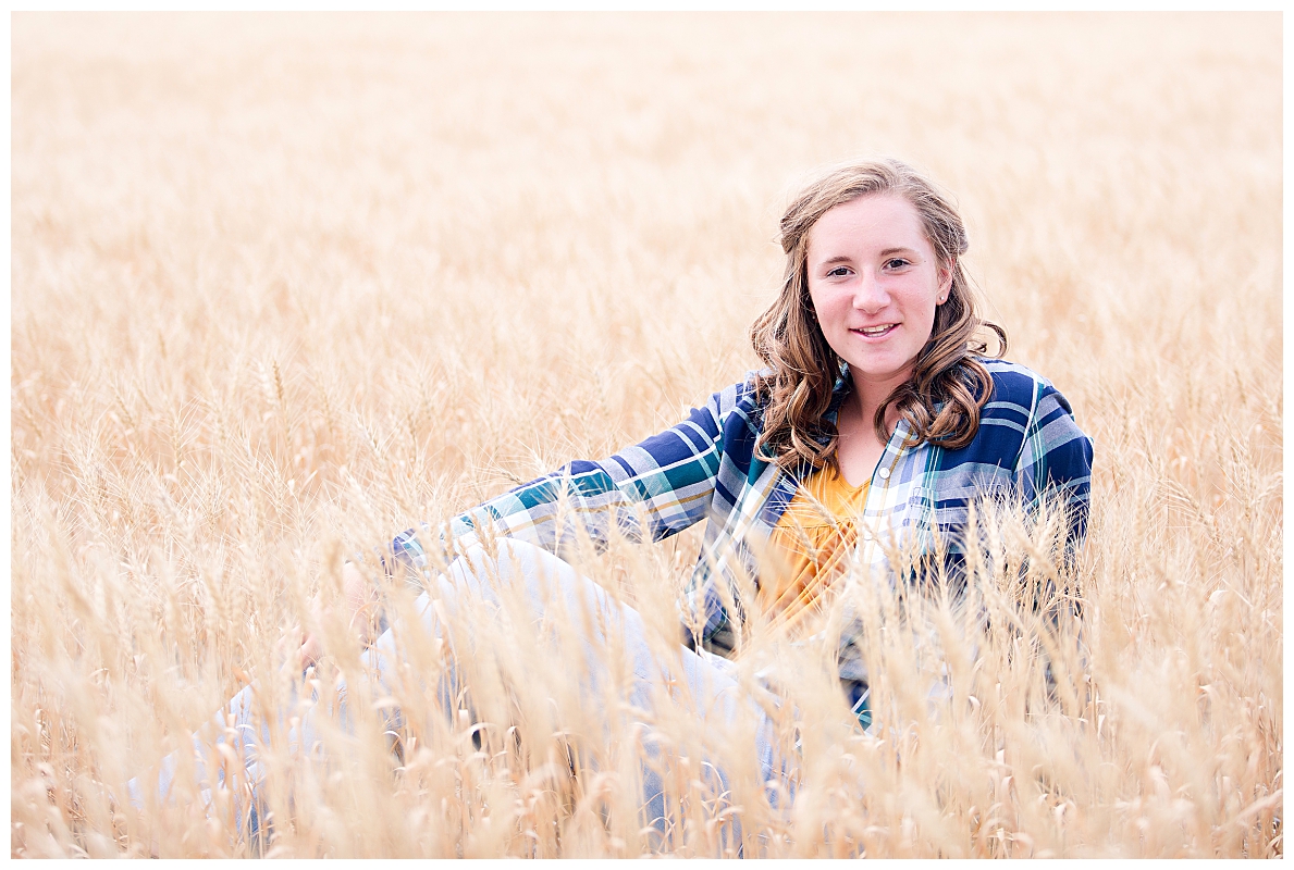 Senior girl sitting in wheat field