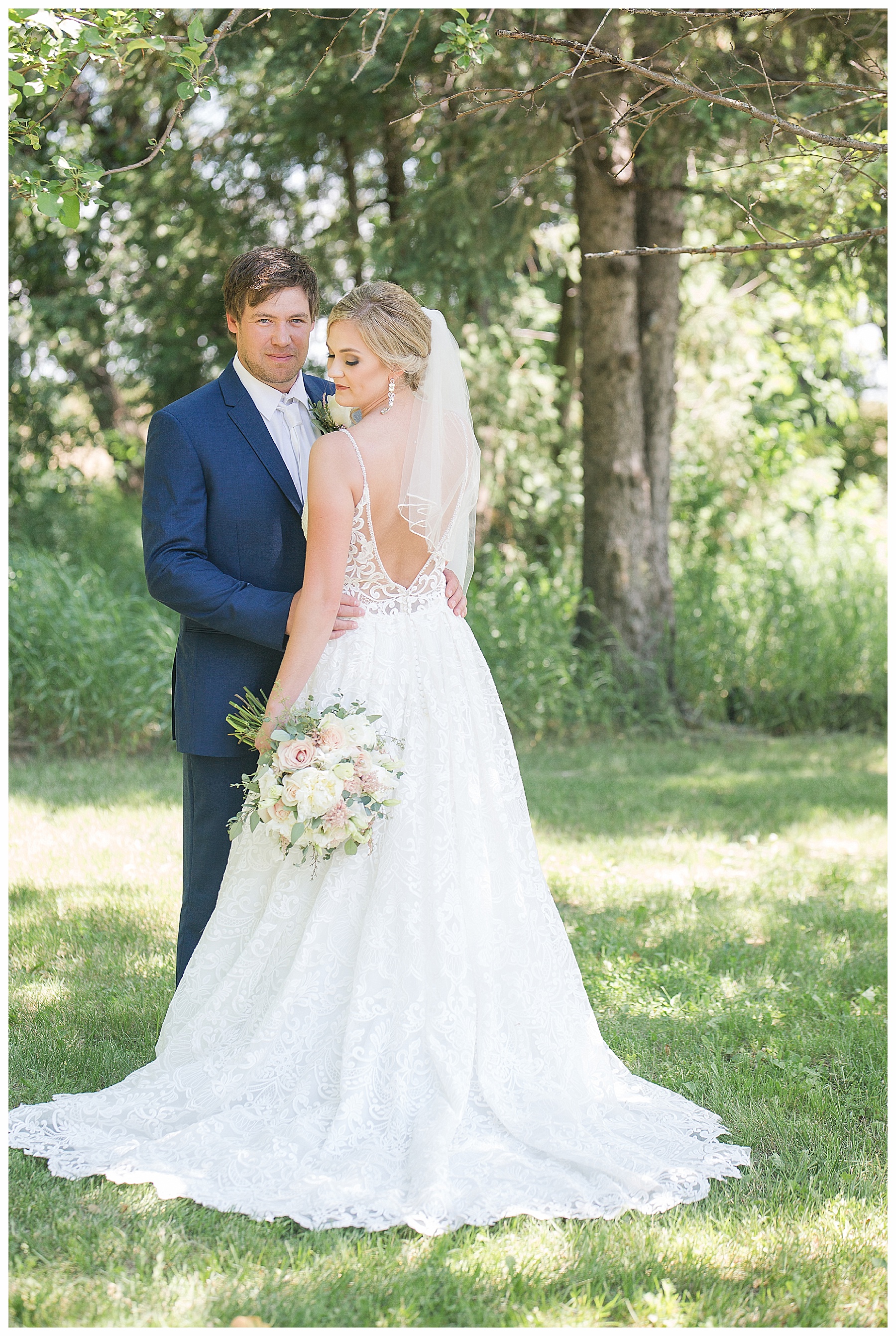 bride wearing short veil with groom wearing navy suit