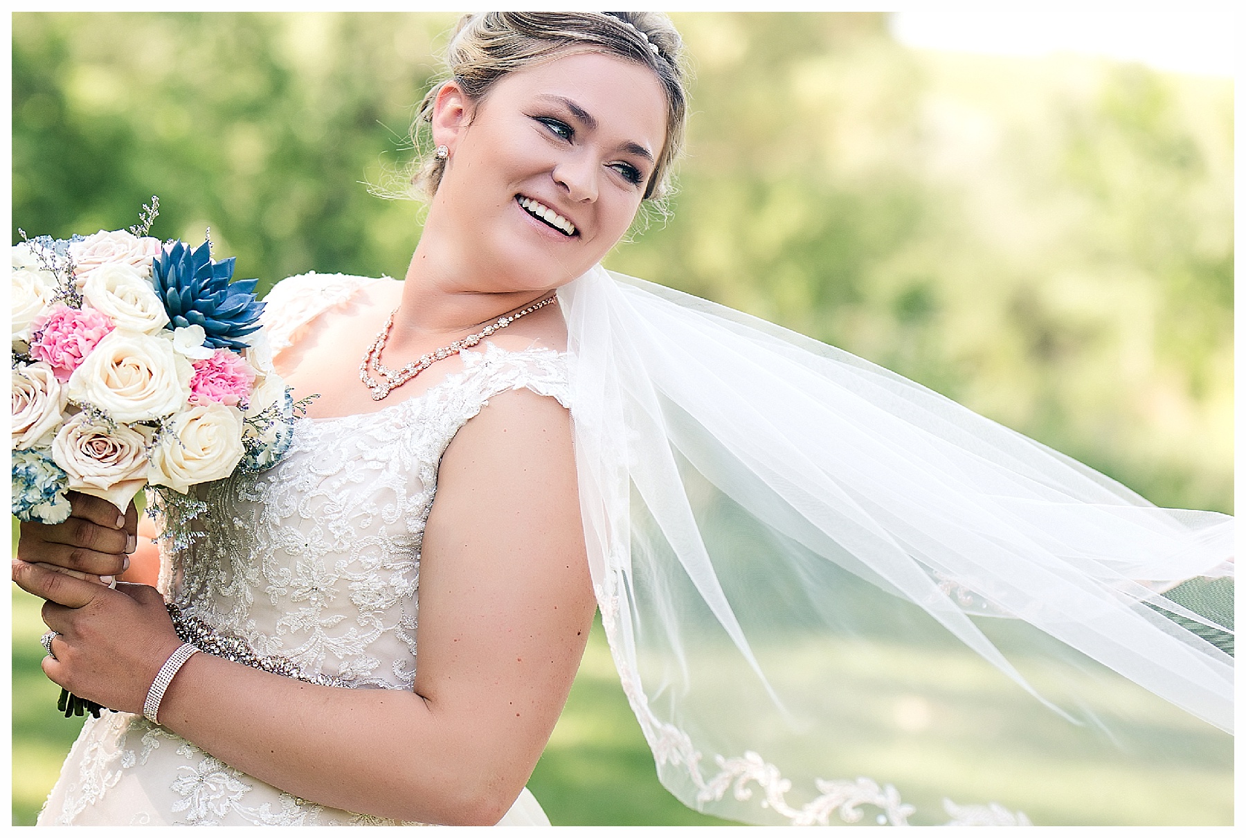 bride laughs and looks back as her veil blows in the wind.  Photo by Bismarck wedding photographer, Photography by Justine