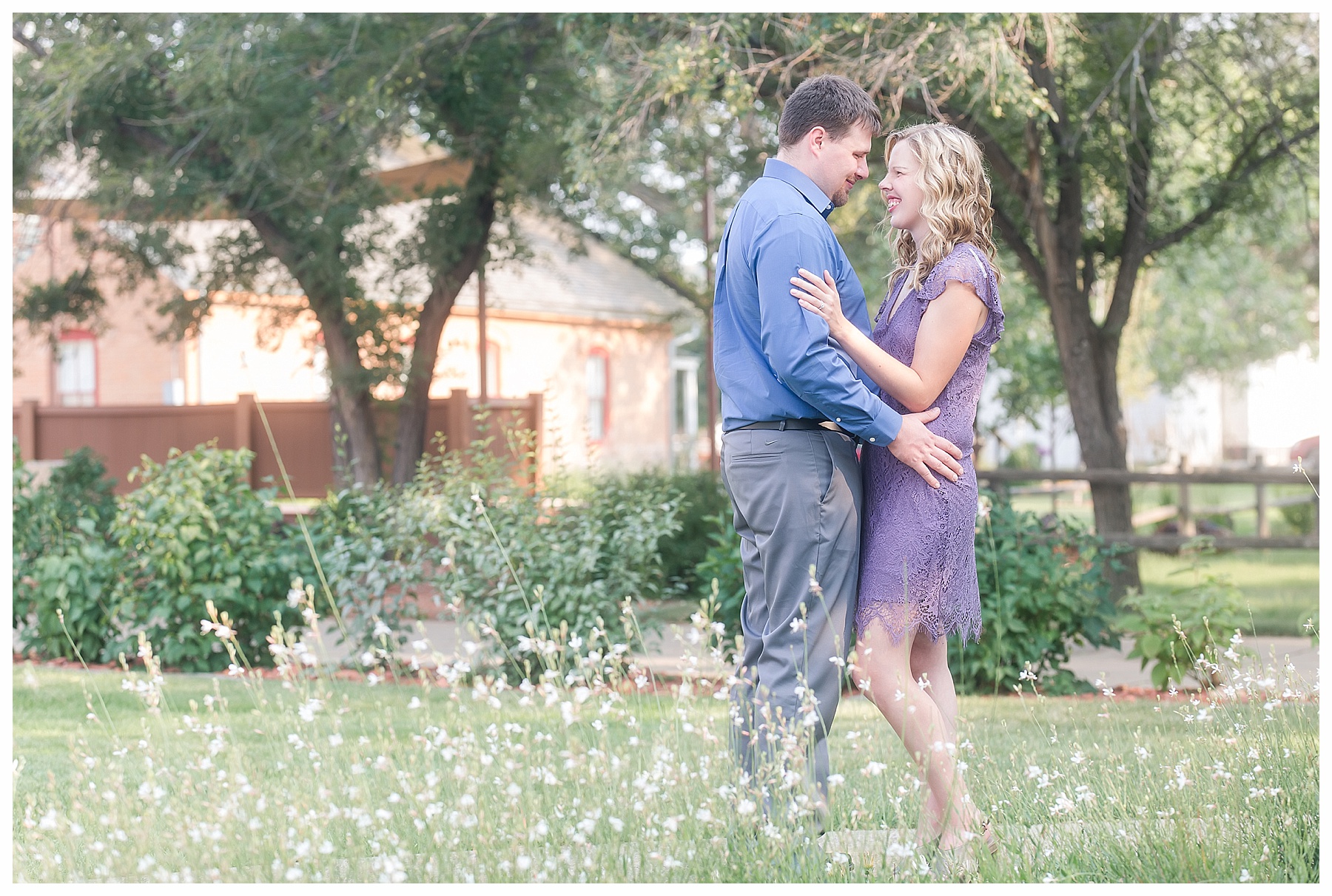 couples stands in white flowers, looking at each other in Medoora ND.  Photo taken by Justine, a wedding photographer in Bismarck ND