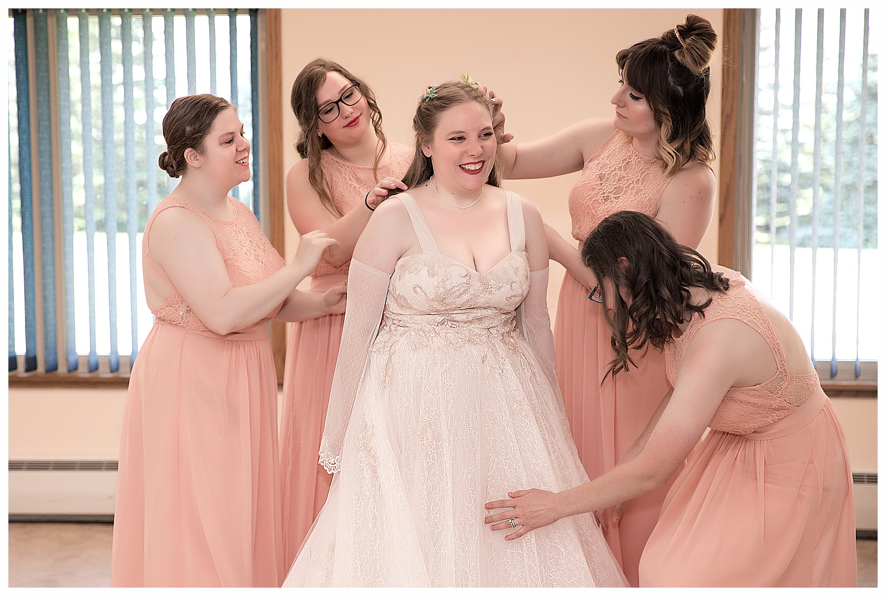 Bride in  getting ready with bridesmaids in peach gowns