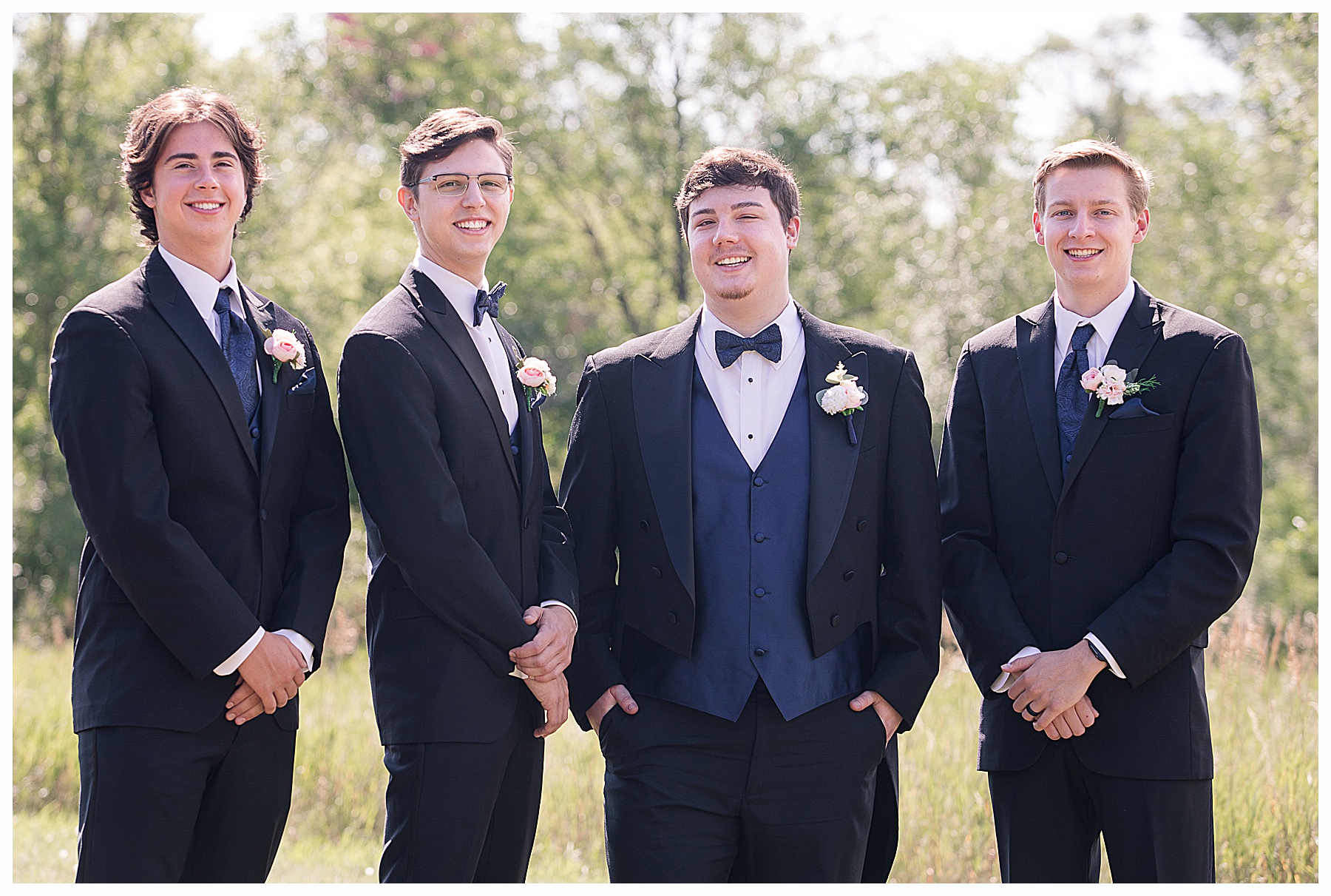 groom in tails with groomsmen in navy vests