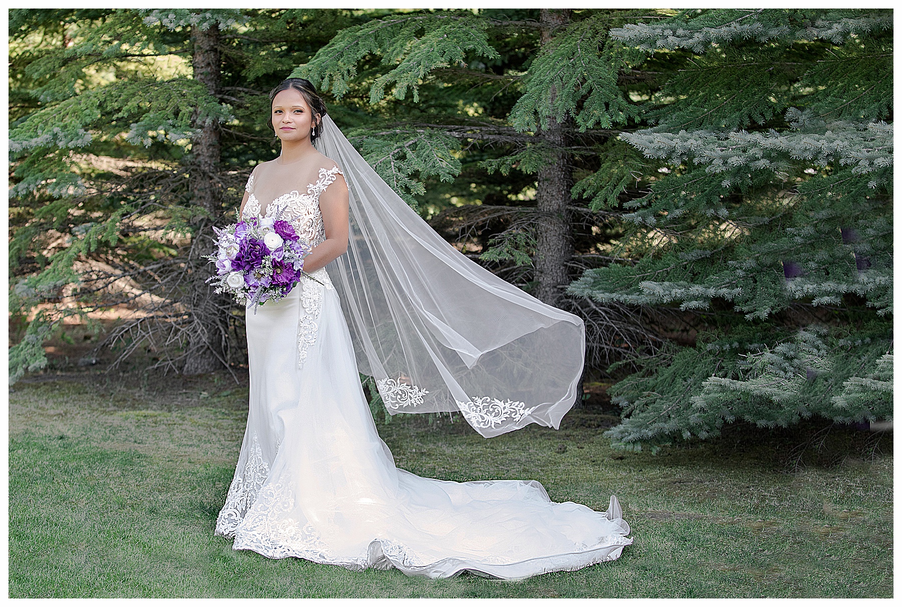 Bride with veil blowing in the wind with purple and white bouquet and custom gown.  Photo by photographer in Bismarck ND Natural Impressions Photography by Justine