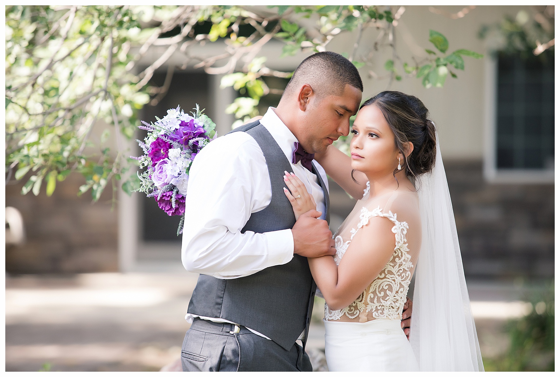 Groom looks at his bride and she looks into distance and holding lavender bouquet.  Photography by Bismarck wedding photographer, Justine