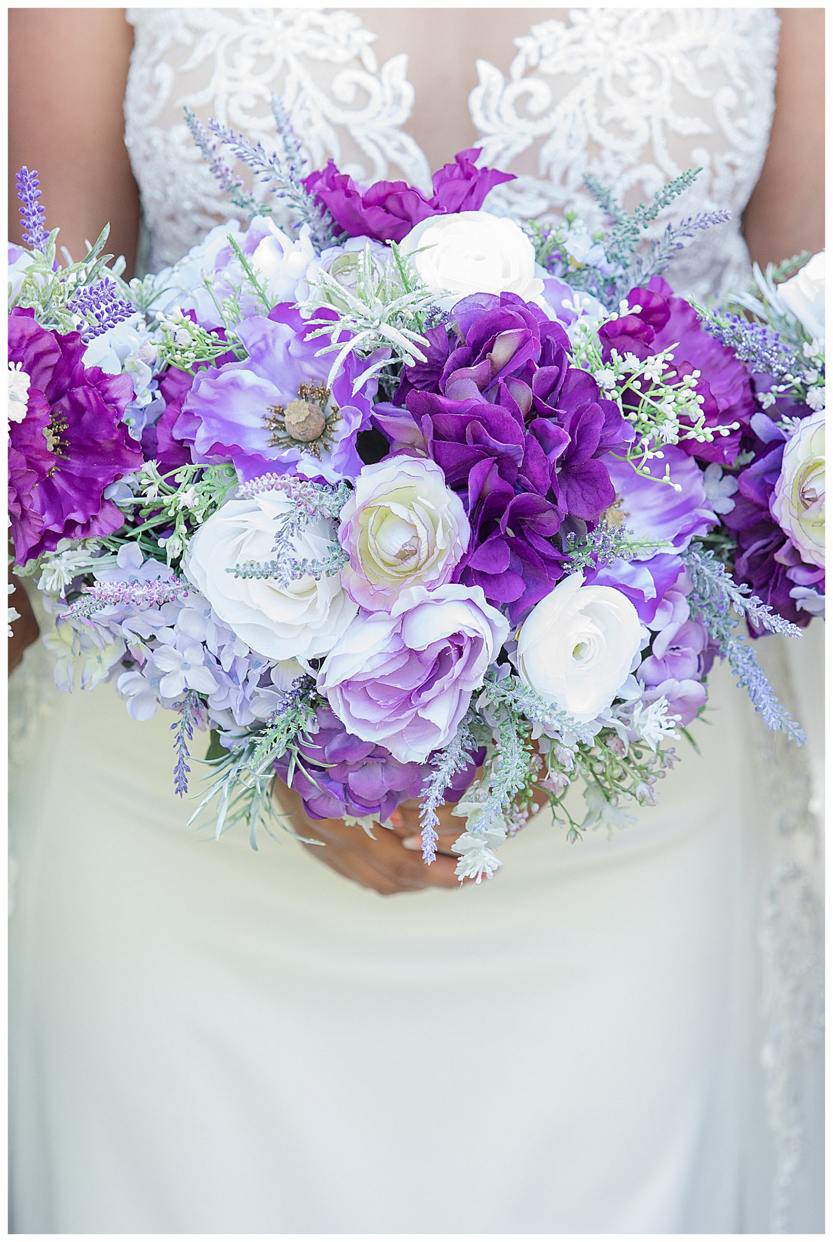 Close up of purple, lavender, sage and white bouquet with wedding gown as background. Photography by Justine, photographer in Bismarck ND