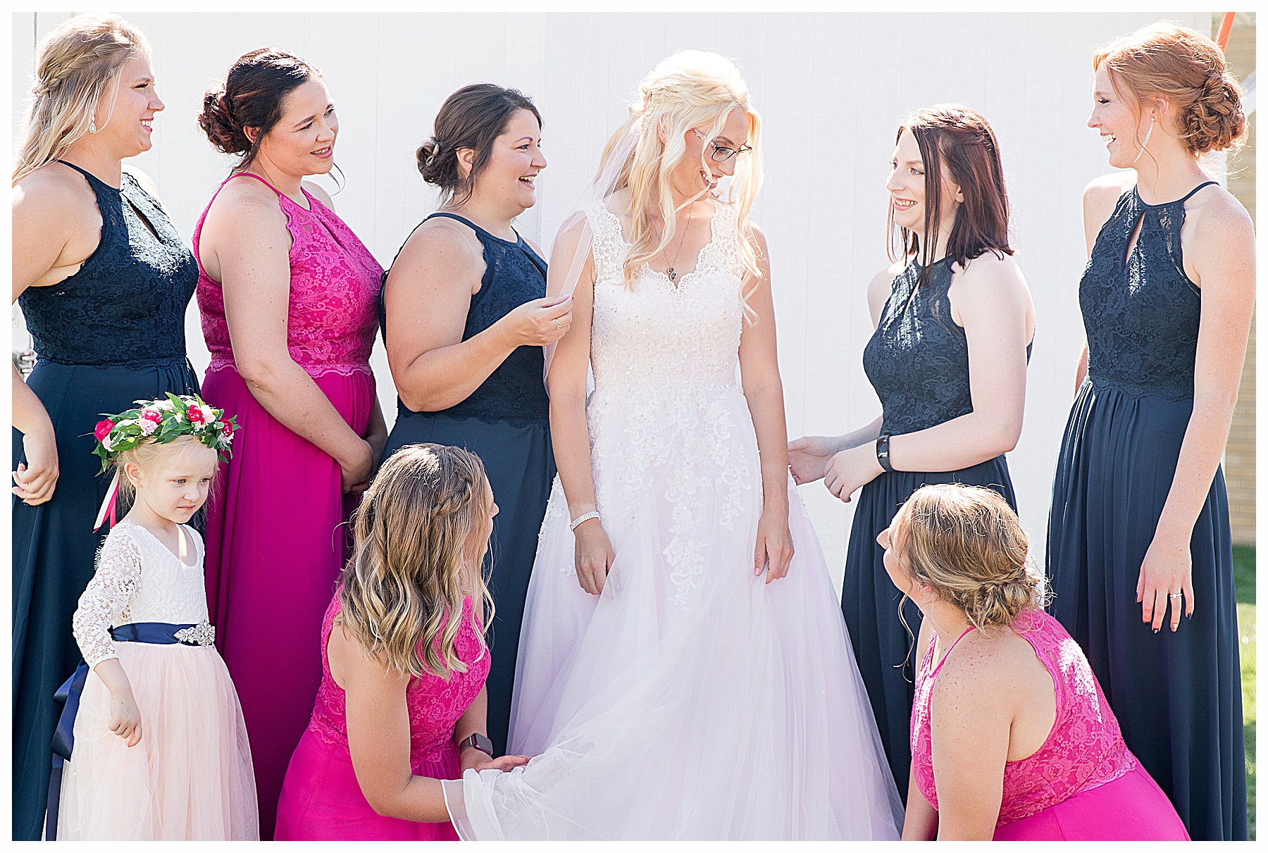 brides maids wearing fuchsia and navy help bride get ready.  Flower girl wearing flower crown