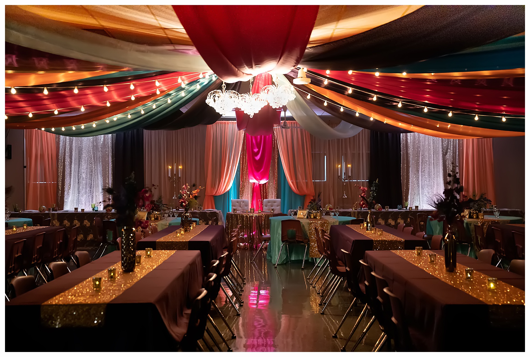 Colorful teal, orange, pink and purple ceiling draping at wedding reception