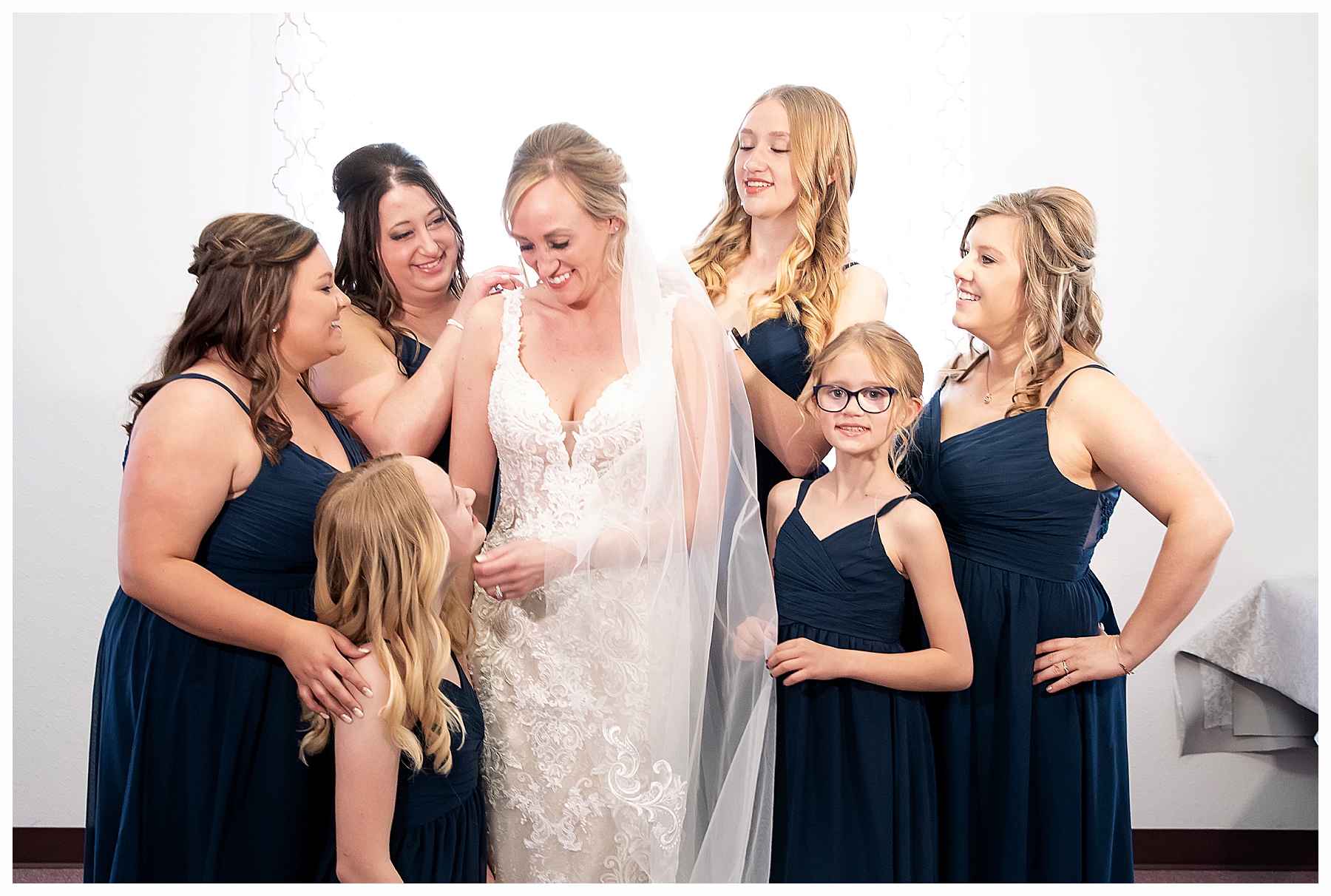 bride surrounded by bridesmaids in navy blue dresses