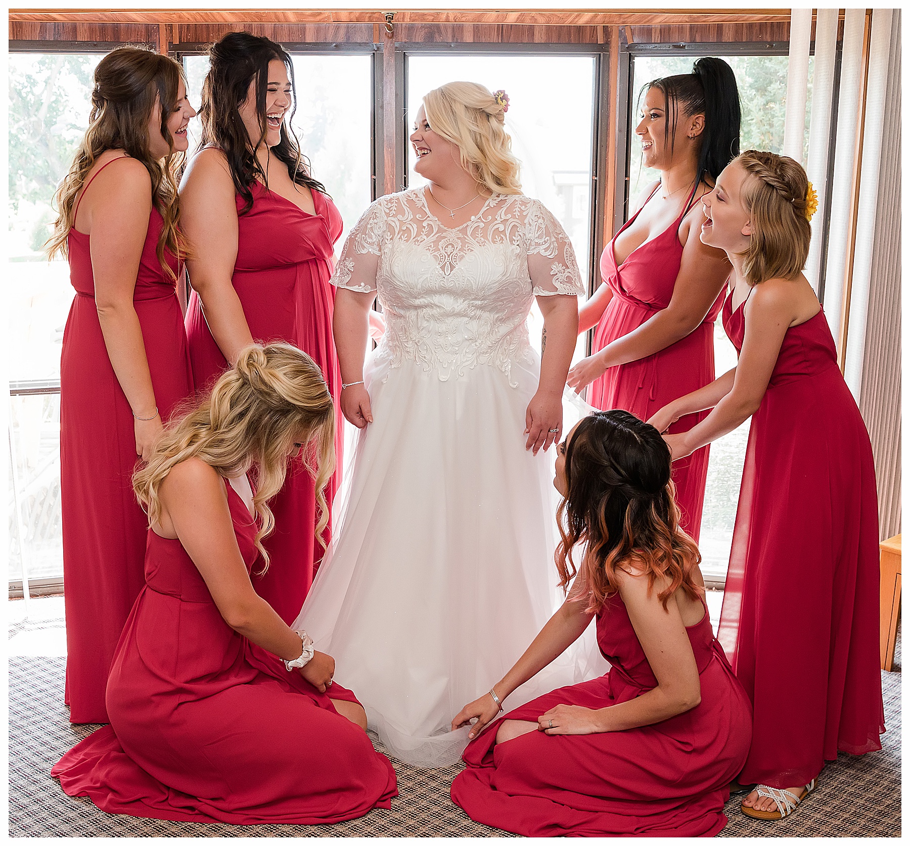 bridesmaids in red dresses help bride get ready