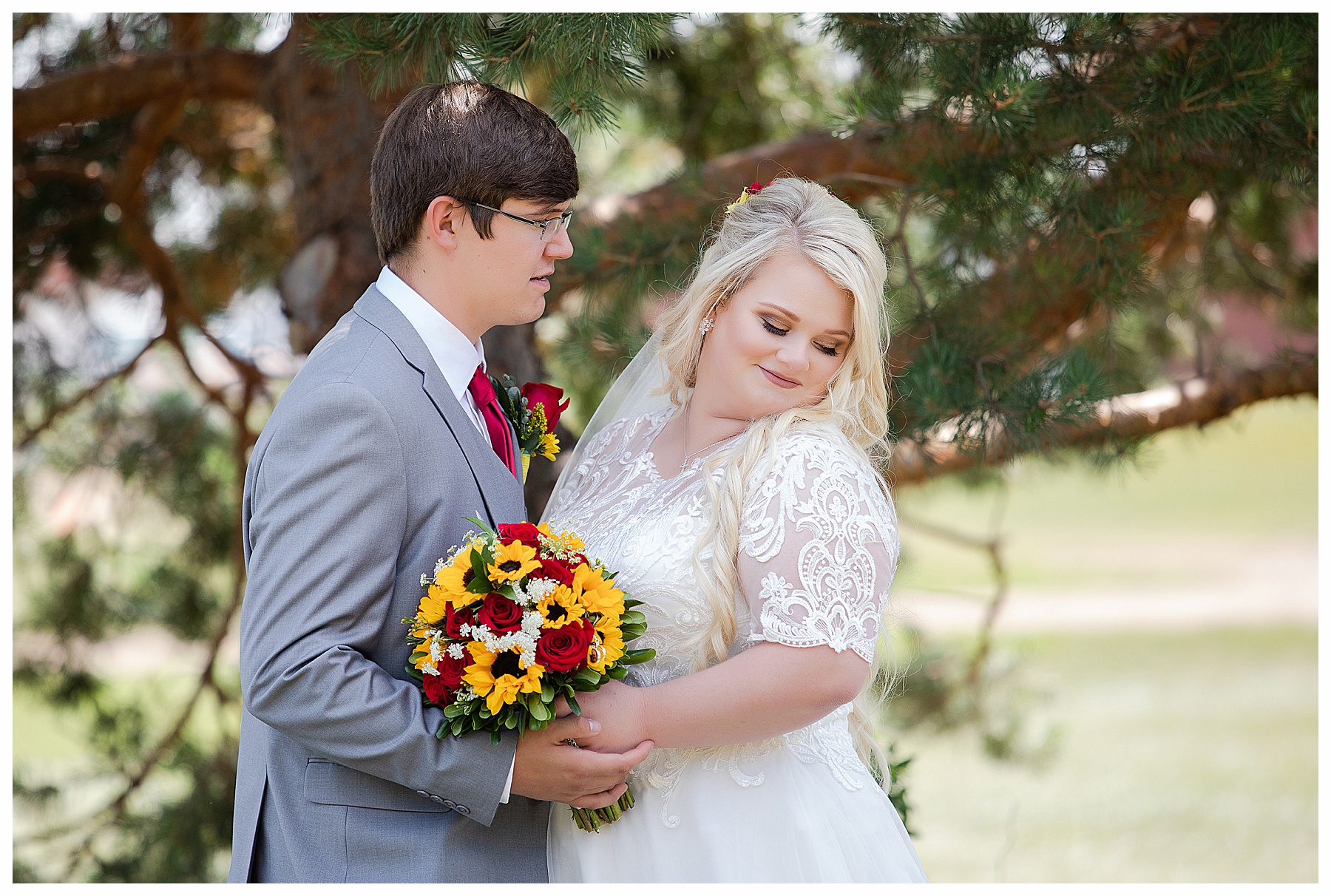 Groom looks at bride holding sunflower bouquet