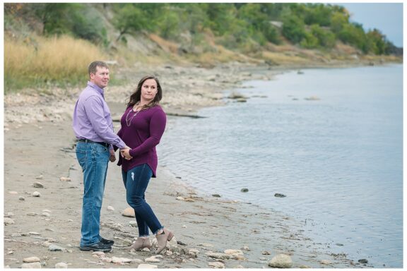 Couple pose by the Missouri River for engagement pictures