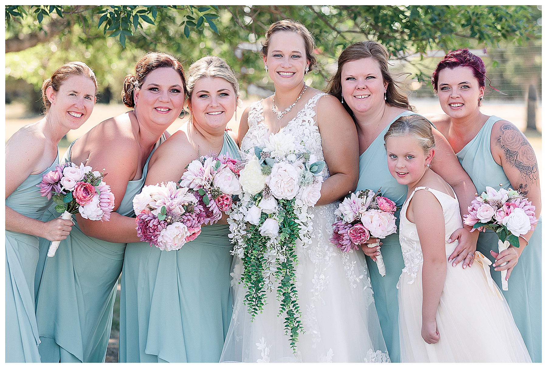 Bride and brides maids wearing soft green and pink bouquets