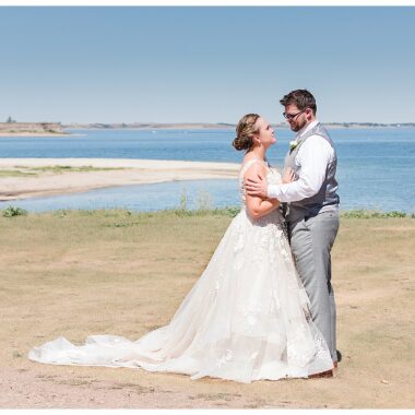 Bride and groom at lake on sunny day