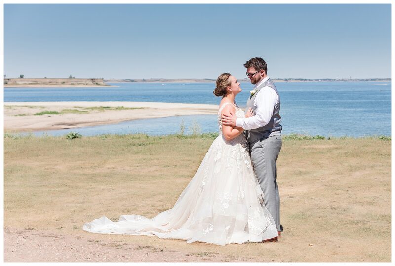 Bride and groom at lake on sunny day