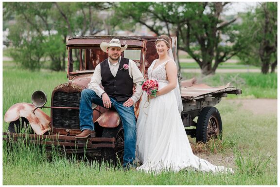 Bride and Groom pose with old vintage rusty truck