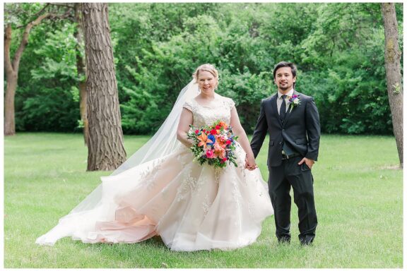 Bride and Groom holding hands and gown blowing in the wind