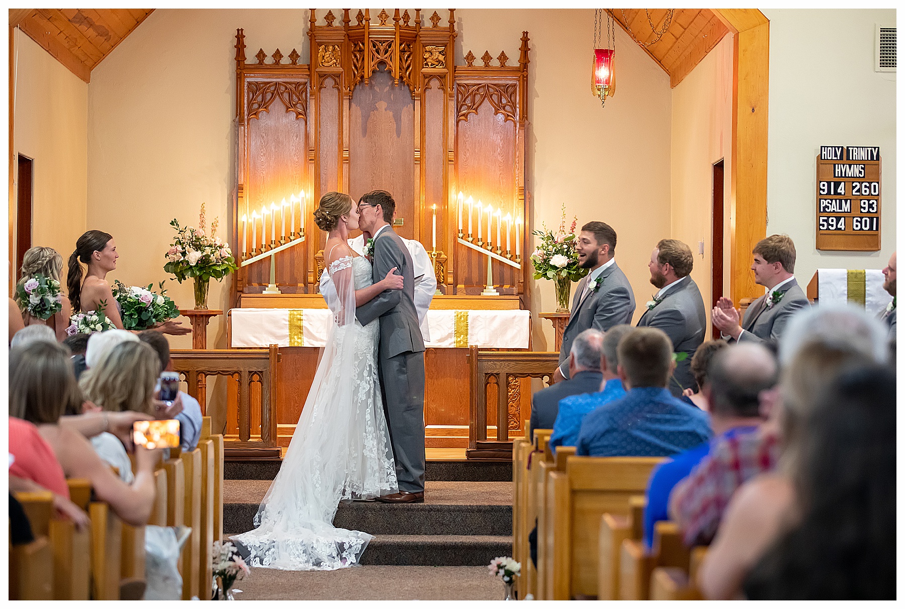 Groom kisses his bride in small country church wedding ceremony.  