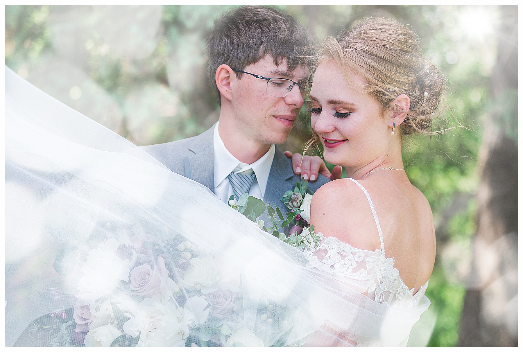 Close up of Bride and Groom with veil in the wind.  Wonderful windy summer  wedding in Bismarck ND