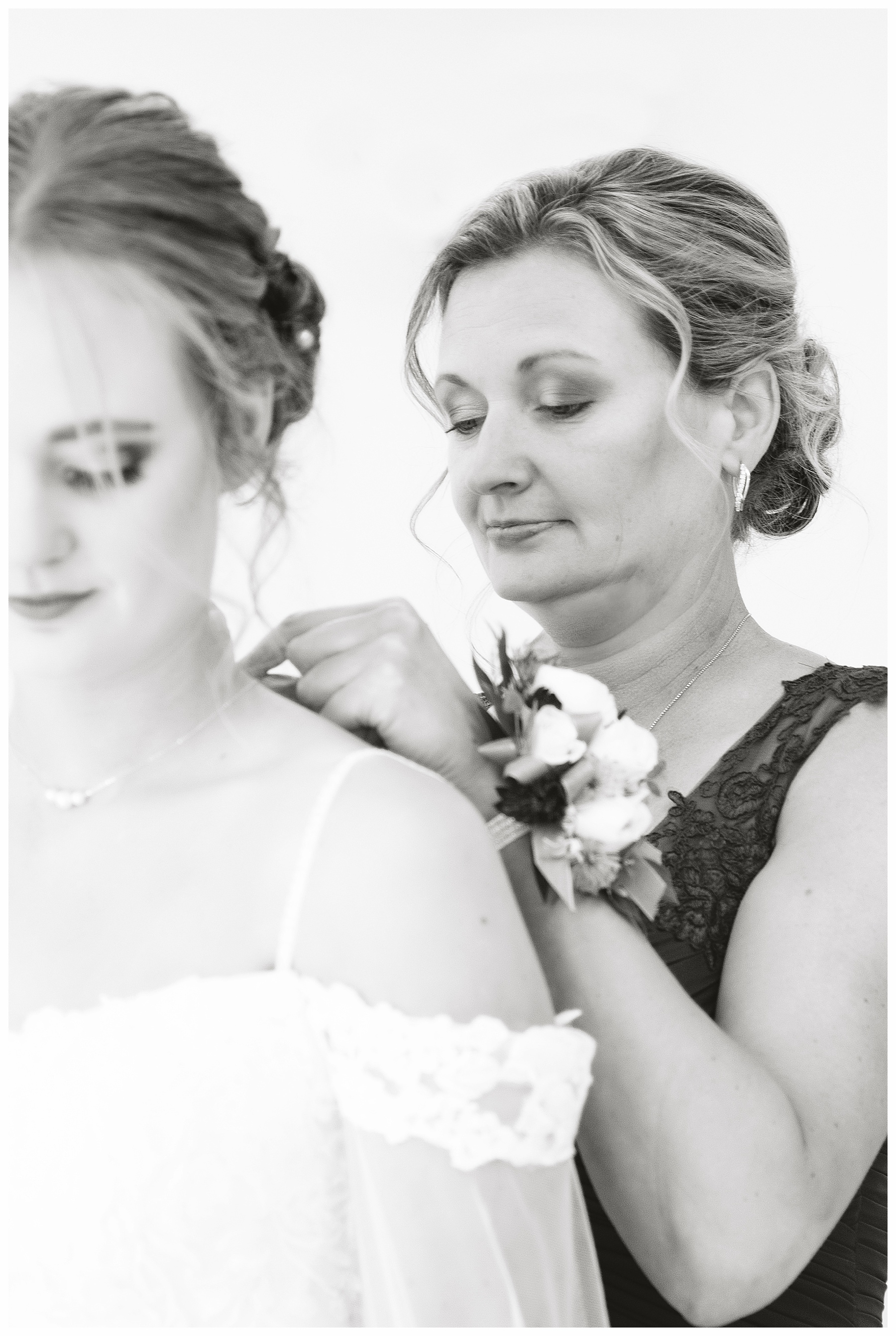 black and white of mother putting necklace on bride.  Wedding photographer in Bismarck ND