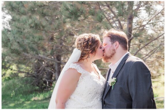 bride and groom kissing on a sunny wedding day