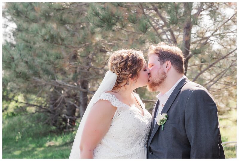 bride and groom kissing on a sunny wedding day